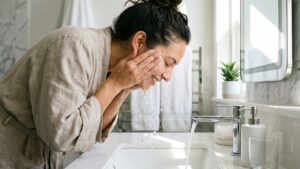 A person practicing proper facial aftercare by using gentle water and avoiding harsh products in San Jose.